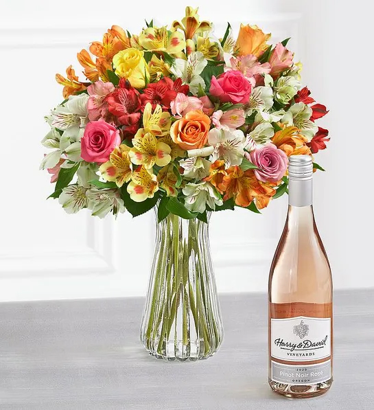 Gifts for couples with a large bouquet of flowers next to a bottle of rosé.