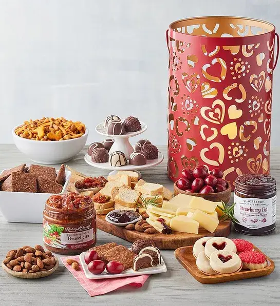 Valentine's Day gifts for her with a Valentine's Day tin lantern next to a selection of sweet and savory snacks.