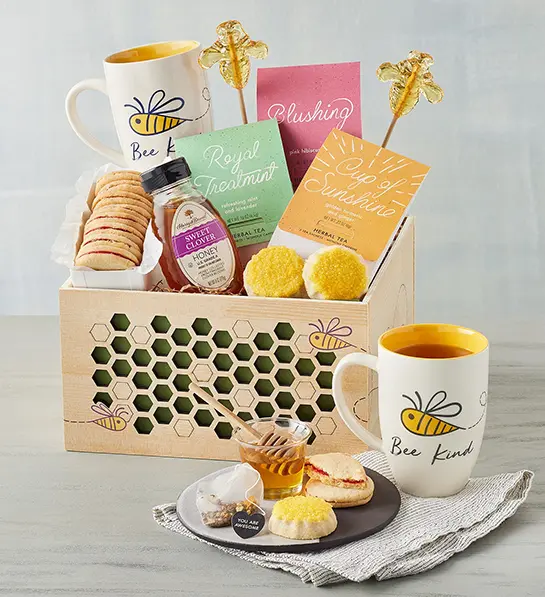 Box of tea with honey, cookies, and other snacks.