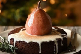 A photo of spice cake with a poached pear on top