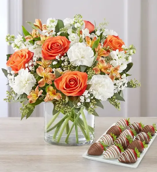 A photo of birthday gifts for sister with a bouquet of flowers next to a plate of chocolate-covered strawberries