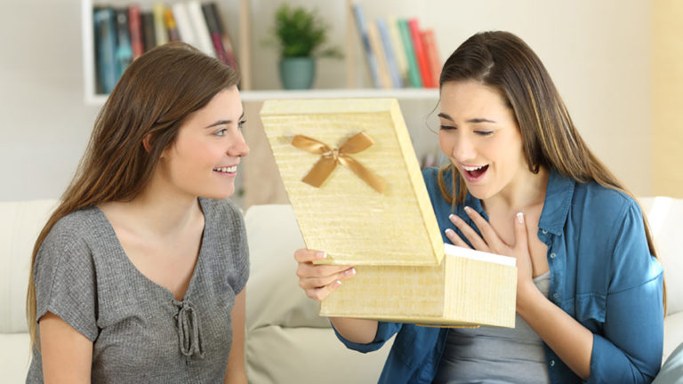 A photo of birthday gifts for sister with two women opening a present