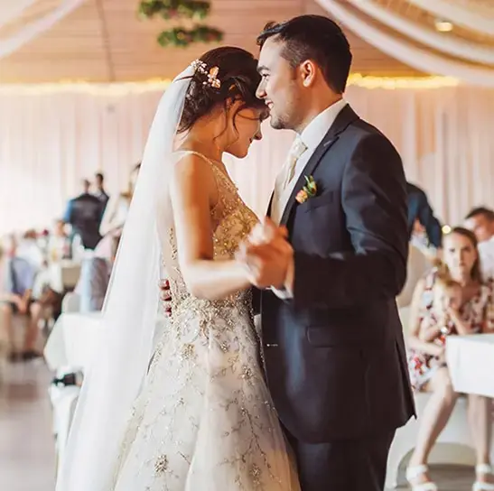 A photo of celebrations community with a bride and groom dancing at a wedding.