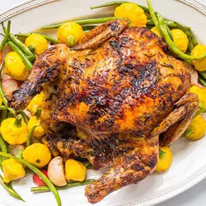 A photo of chicken recipes with a roast chicken on a plate of roast vegetables