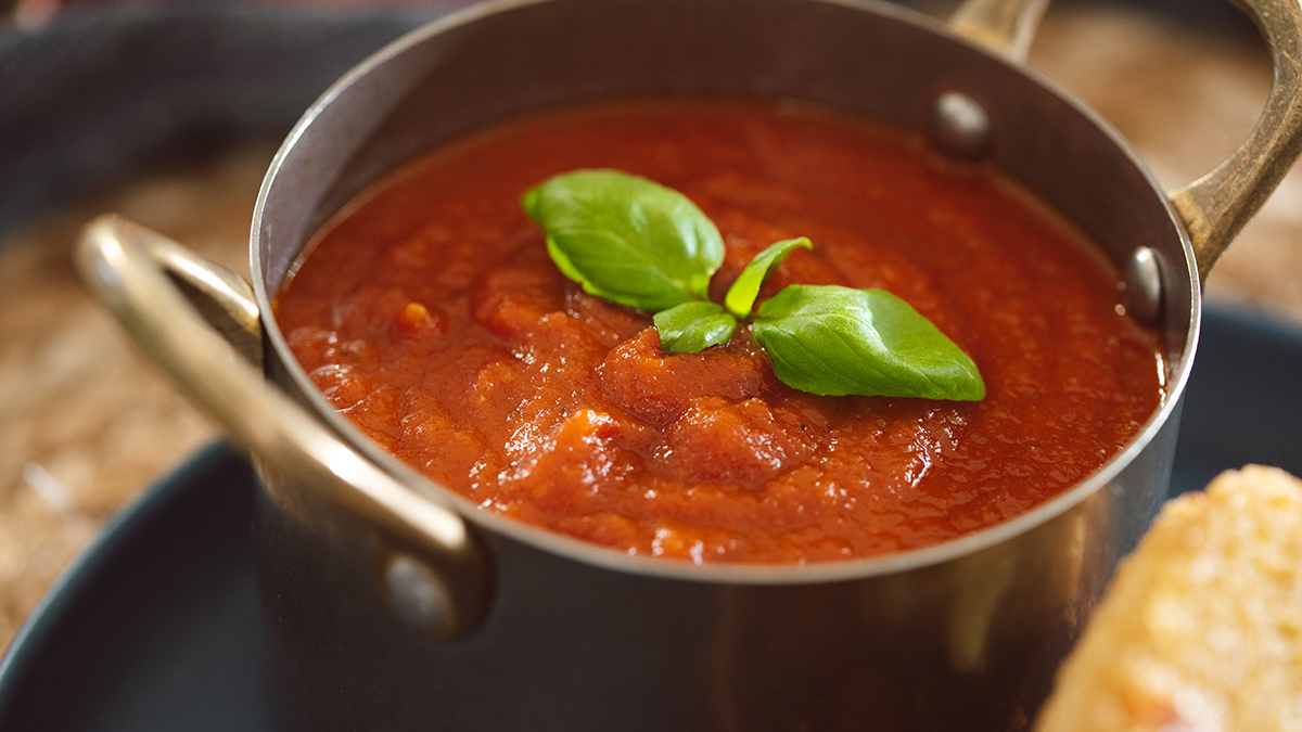 A photo of grilled cheese with a closeup of a bowl of tomato soup