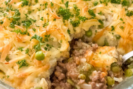 A photo of shepherd's pie with a spoon cutting into the pie