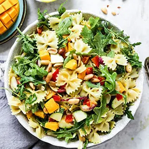 A photo of spring recipes with a bowl of mango pasta salad