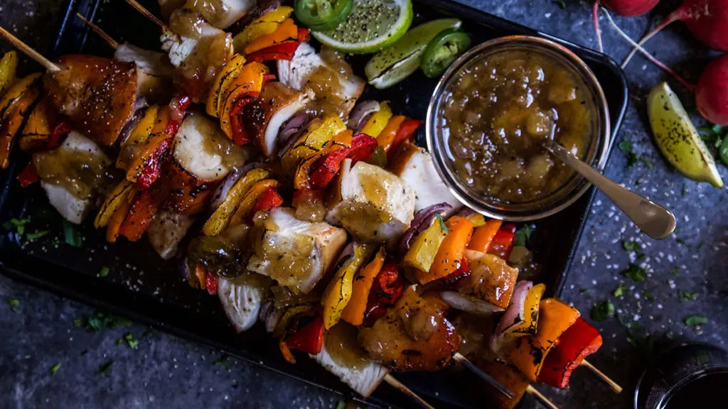 A photo of teriyaki chicken with a plate of chicken skewers.