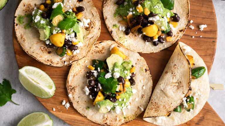 A photo of vegetarian tacos on a wooden cutting board