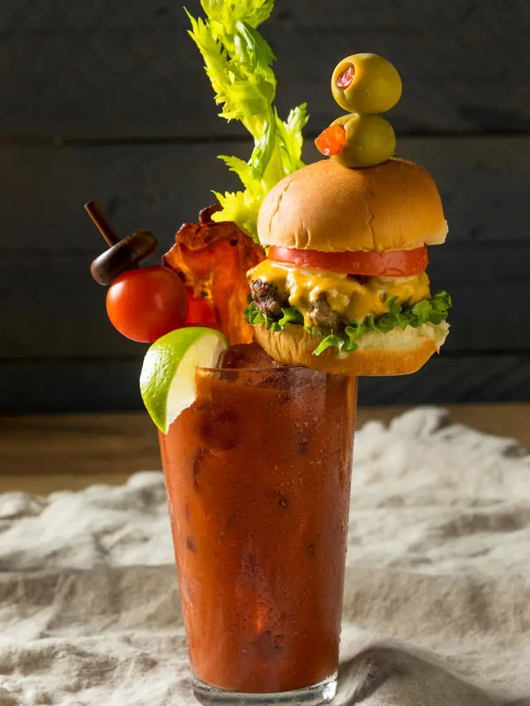 A photo of a bloody mary with a burger as a garnish