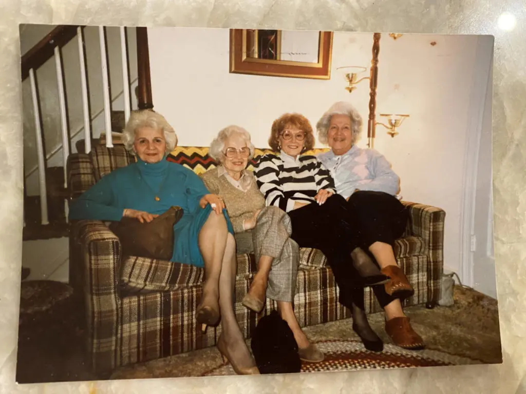 A photo of blueberry pie with a group of older women sitting on a couch