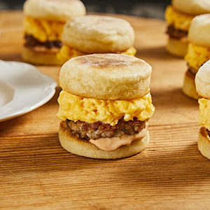 A photo of breakfast recipes with several mini breakfast sandwiches on a table