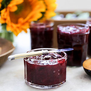 A photo of breakfast recipes with a pot of plum jam
