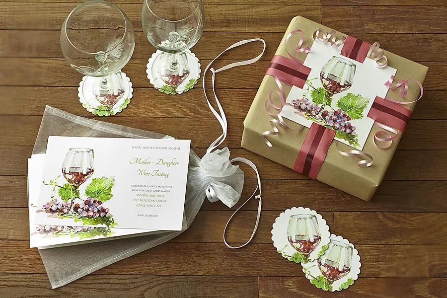 A photo of mother's day wine tasting with invitations next to a wrapped gift with two glasses.