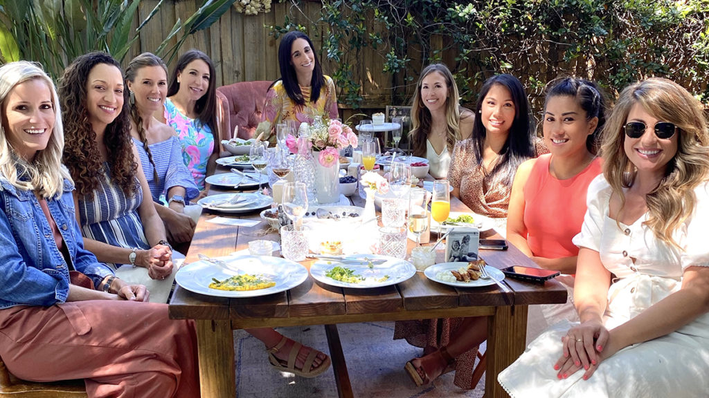 A photo of mother's day brunch recipes with a group of women sitting at a table outside