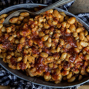 A photo of slow cooker recipes with a bowl of baked beans