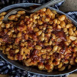 A photo of slow cooker recipes with a bowl of baked beans