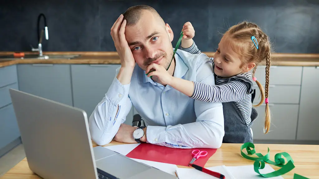 This is an image of daddy brain. A little girl distracting her father while he's working from home.