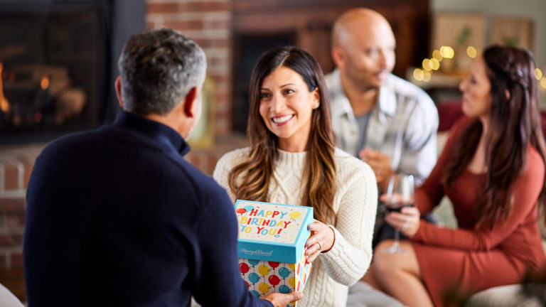 A photo of gift history with a woman giving a man a birthday gift