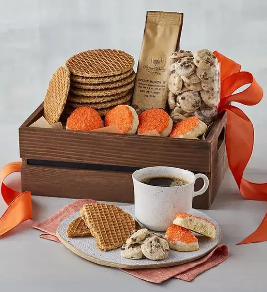 A photo of graduation gift ideas with a basket of cookies next to a plate of cookies and full cup of coffee