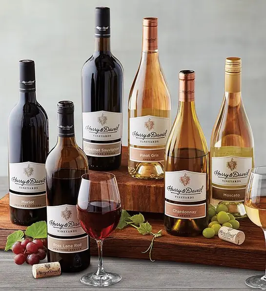 A photo of graduation gift ideas with six bottles of wine on a table.