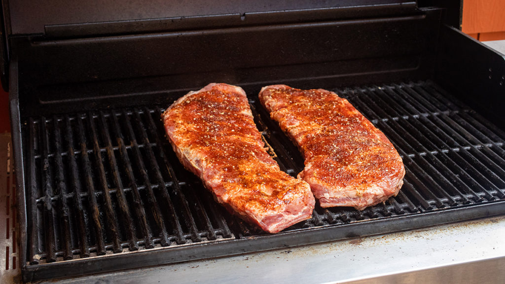 A photo of grill ribs with two racks of ribs on a grill