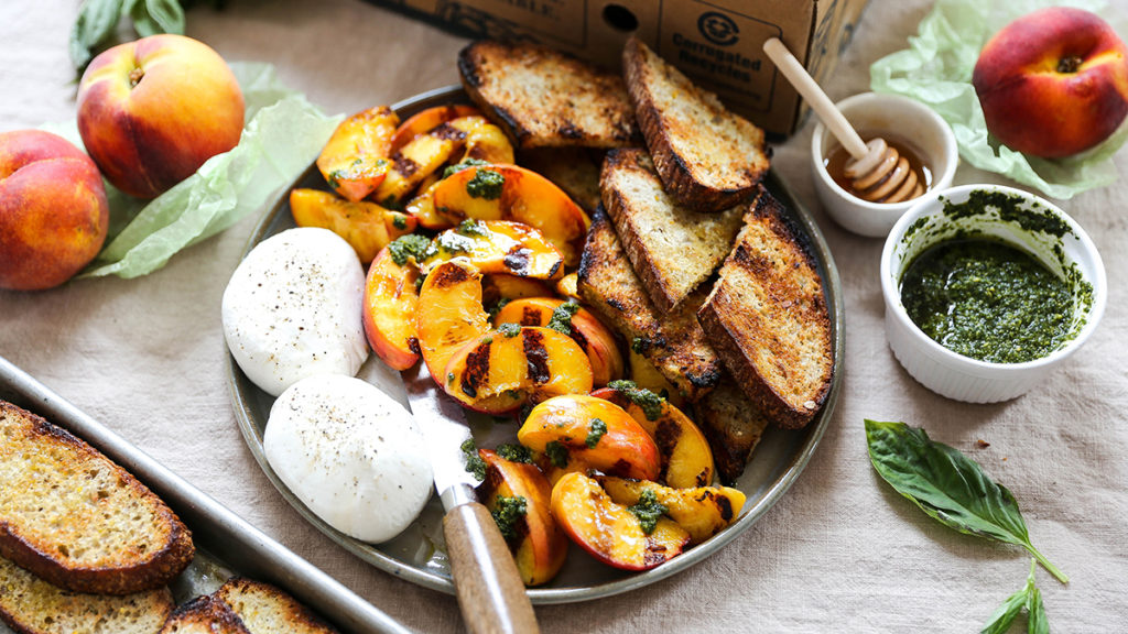 A photo of june recipes with a plate of grilled peaches, burrata and toasted bread