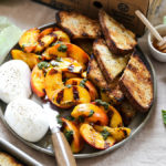 A photo of june recipes with a plate of grilled peaches, burrata and toasted bread