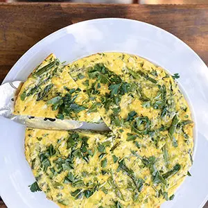 A photo of june recipes with a spring vegetable frittata on a plate