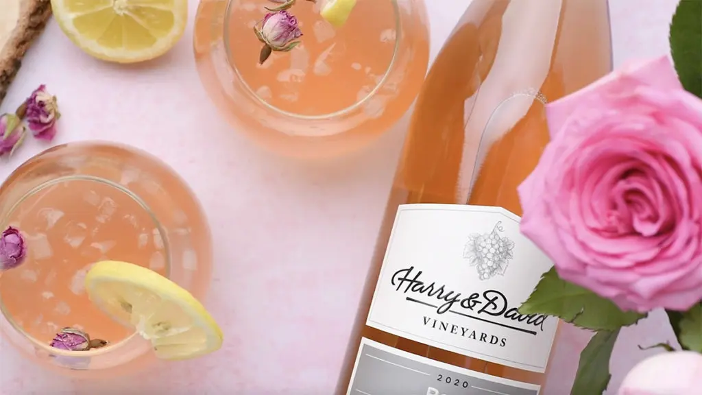 A photo of a lemonade cocktail with two glasses of rose lemonade next to a glass of rose wine lying on its side