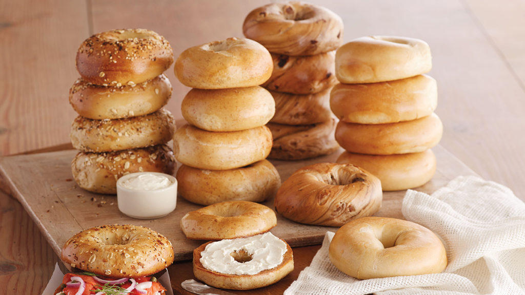 A photo of origin of the bagel with a stack of bagels on a wooden table