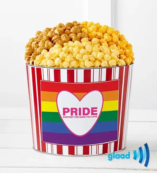 A photo of pride month gifts with a tin of popcorn decorated with rainbows