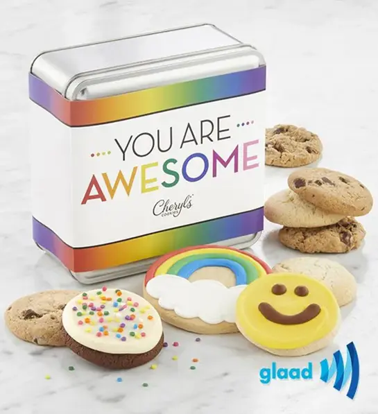 A photo of pride month gifts with a tin with the words "you are awesome" across it surrounded by cookies