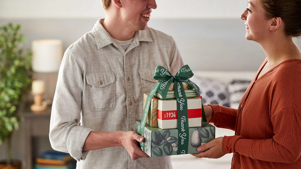 A photo of a thank you gift with a man giving a woman a thank you gift