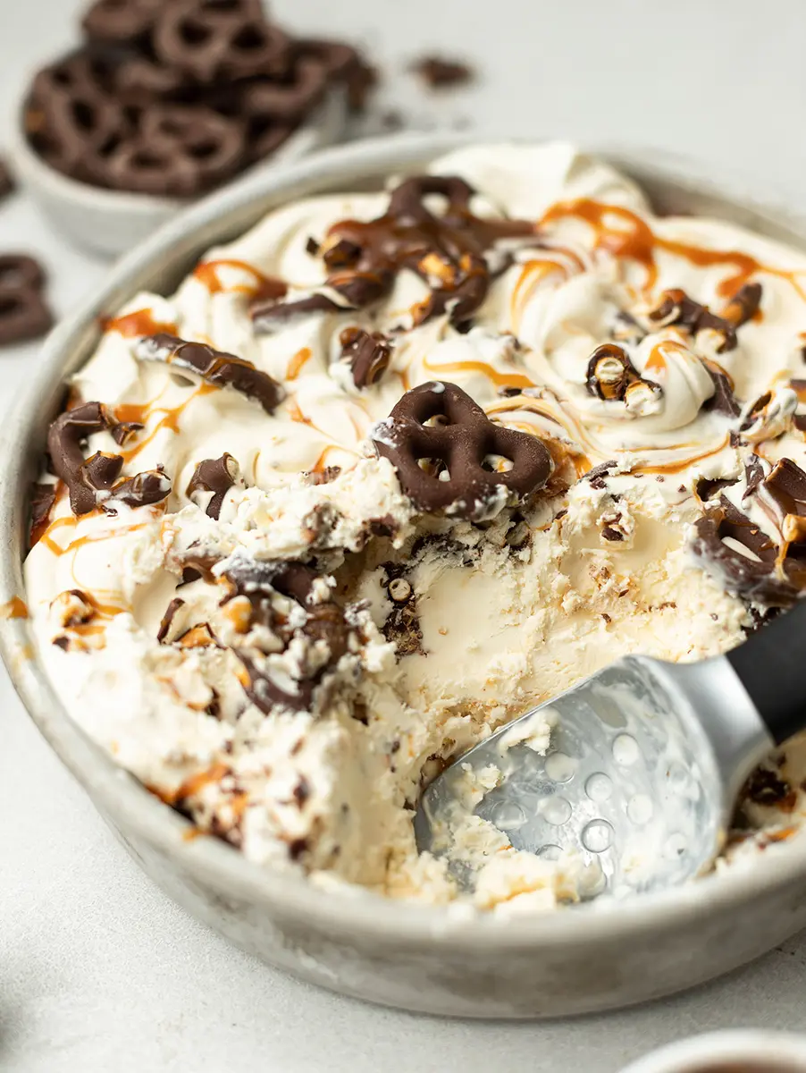 Photo of caramel ice cream in a bowl with chocolate covered pretzels