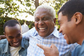 A photo of dad jokes with three man laughing with their arms around each other.