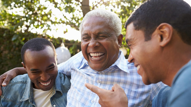 A photo of dad jokes with three man laughing with their arms around each other.