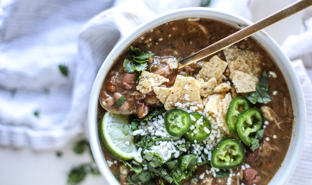 Food puns with a bowl of chicken chili topped with jalapenos.