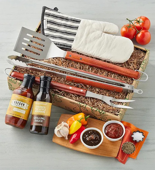 Photo of grilling gifts with a barbecue kit in a box surrounded by bbq sauce.
