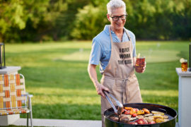Photo of grilling gifts with a man grilling meat and vegetables outside.