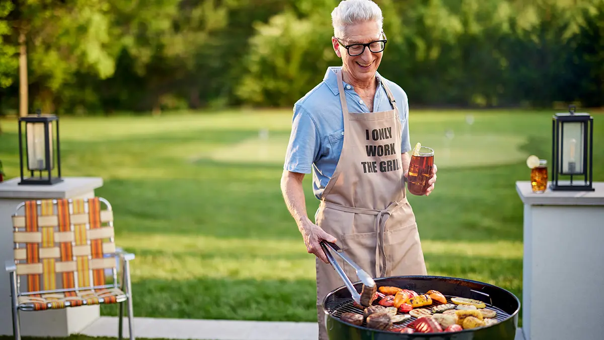 Photo of grilling gifts with a man grilling meat and vegetables outside.