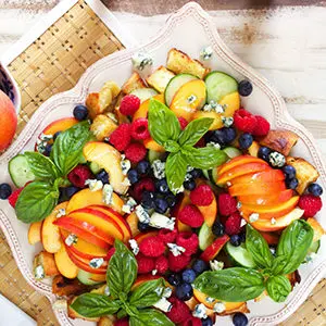Photo of july recipes with a peach panzanella salad on a platter.