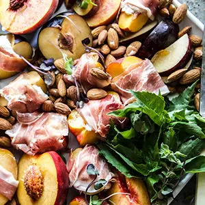 Photo of july recipes with a plate of prosciutto wrapped stone fruit.