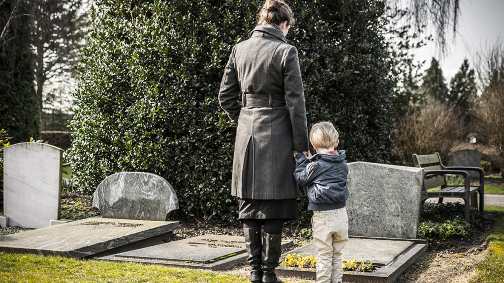 Photo of loss of dad on father's day with a woman and child at a grave