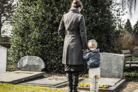 Photo of loss of dad on father's day with a woman and child at a grave