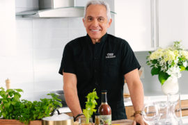 Photo of summer entertaining recipes with Geoffrey Zakarian standing in a kitchen.