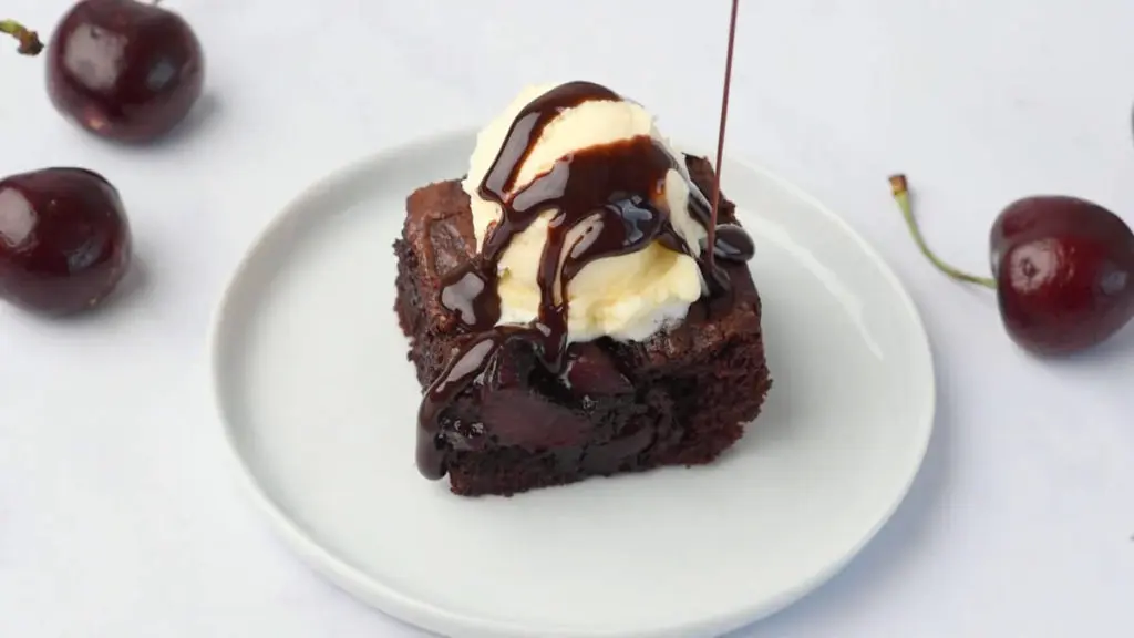 Cherry chocolate brownie with vanilla icecream and chocolate syrup on top