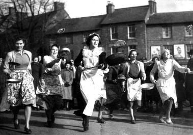 Bucket list. A photo of the Olney pancake race in 1950, women race while holding pancakes in skillets.
