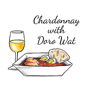 Global cuisine wine pairings with a glass of chardonnay next to a bowl of doro wat