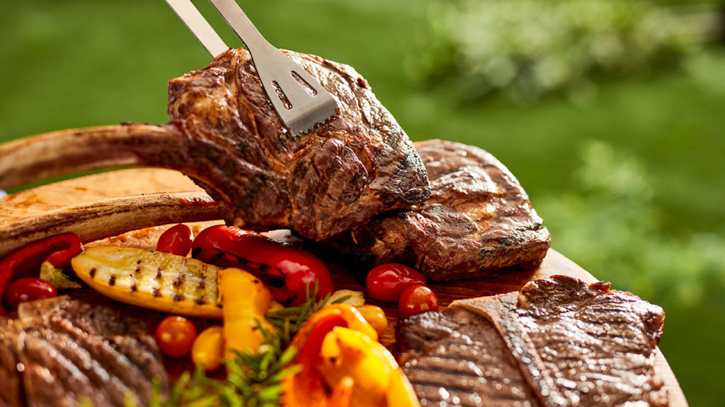 Photo of how to grill with a tomahawk steak on a grill with vegetables